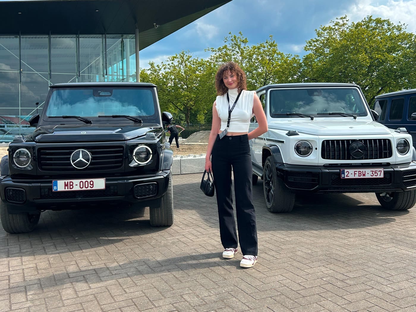 Creator at a Mercedes-Benz G-Class event, standing between a black and a white G-Class