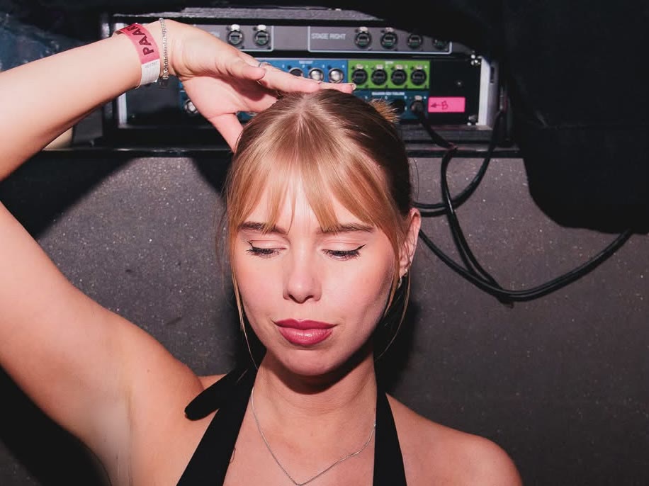 Backstage portrait of a VETA talent, eyes closed, hand in her hair